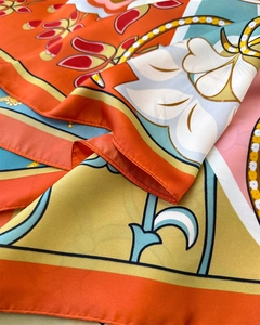 Close-up of silk-feel scarf showing vibrant floral prints and rolled edge stitching