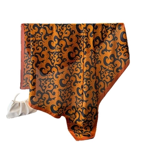Elegant satin scarf with orange and black swirl print and pearl chain cloud bag