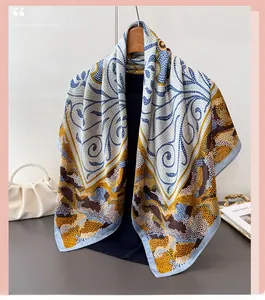 Détail d'un élégant foulard en soie à imprimé géométrique bleu et doré sur cintre en bois