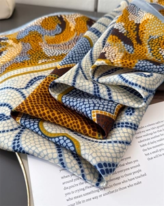 Détail du foulard à imprimé abstrait coloré avec texture soyeuse et bordure roulée