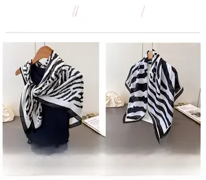 Detail view of two zebra pattern fashion scarves in classic black and white color