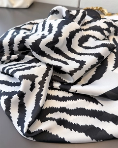 Detail of silk-feel scarf with black and white zebra print and elegant flowing texture