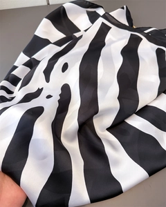 Detailed view of striped silk scarf with elegant black and white zebra pattern texture