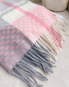 Close-up of pink and grey plaid scarf showing soft cashmere-like texture and fringe detail