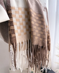 Close-up of classic plaid cashmere-like scarf showing texture and fringe tassels