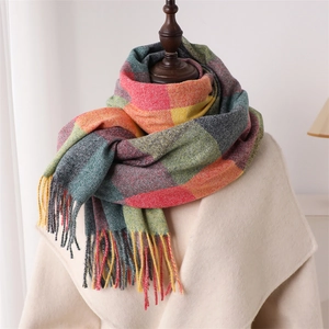 Détail du motif à carreaux colorés et des longues franges de l'écharpe douce au toucher