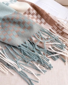 Macro detail of soft plaid scarf texture with blue and beige fringe on cloth background