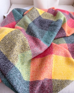 Gros plan sur une écharpe à carreaux multicolore montrant la texture douce et les franges