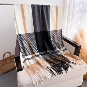 Detail of plaid scarf with fringe on an armchair, showing thick knit texture and colors