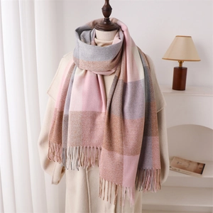Détail d'une écharpe à carreaux rose et gris avec des franges douces pour l'hiver