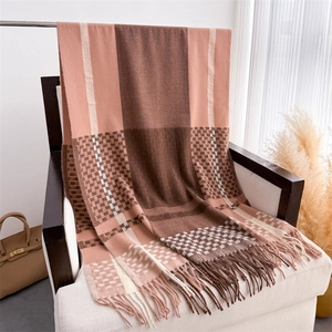 Detail of plaid scarf with tassels, featuring pink and brown checkered knit texture