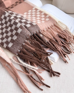 Close-up of knit plaid scarf with brown check pattern and long tassel details