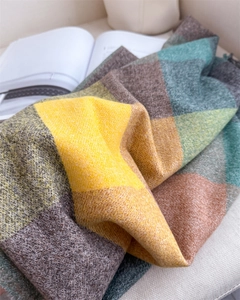Texture détaillée d'une écharpe d'hiver épaisse à carreaux multicolores sur un canapé