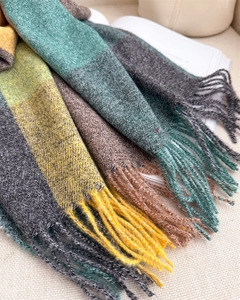 Gros plan sur l'écharpe à carreaux colorée montrant les franges et la texture du tissage