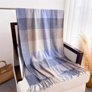 Détail de l'écharpe à carreaux multicolores avec franges sur une chaise blanche