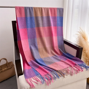 Détail d'une écharpe à carreaux multicolores avec de longues franges et maille douce
