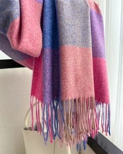 Gros plan de l'écharpe à carreaux rose et bleu avec texture pelucheuse et franges