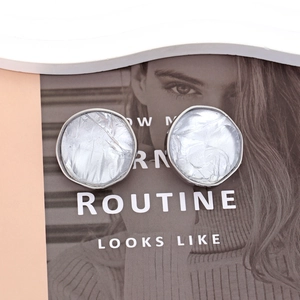 Irregular textured silver stud earrings featuring geometric resin and metallic details