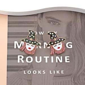 Detailed view of witch hat earrings with pink rhinestones on a fashion magazine