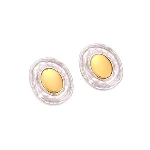 Close-up of oval alloy stud earrings with two-tone gold center and silver hammered texture
