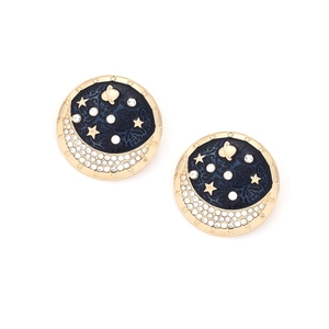 Close-up of star and moon stud earrings with blue enamel and sparkling crystals