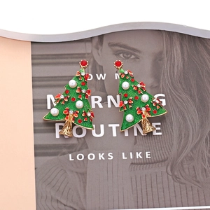 Boucles d'oreilles sapin de Noël en émail vert avec strass rouges et perles sur magazine