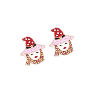 Close-up of cartoon girl earrings with red hat, enamel details and colorful rhinestones
