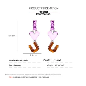 Detail view of purple resin heart drop earrings with size specs and material info