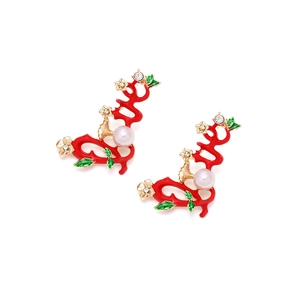 Détail de boucles d'oreilles vignes avec branches en émail rouge, feuilles et perle