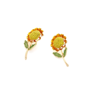 Boucles d'oreilles tournesol dorées avec cristaux jaunes et verts sur fond blanc