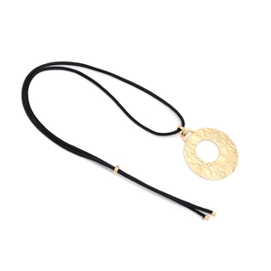 Collier minimaliste avec pendentif rond doré texturé et cordon noir sur fond blanc