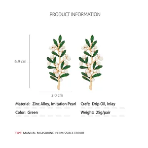 Elegant gold leaf earrings with green enamel and faux pearls on a white background