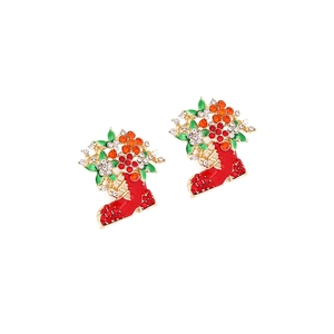 Détail de boucles d'oreilles bottes de Noël avec strass rouges et fleurs émaillées