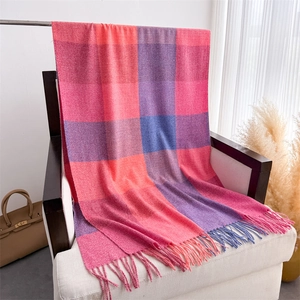 Détails de la texture d'une écharpe à carreaux colorés avec franges sur un fauteuil blanc