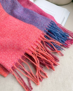 Gros plan sur l'écharpe à carreaux rose et violette avec texture tricotée et franges
