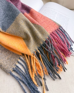 Gros plan détaillé des franges du foulard à carreaux multicolores et texture cachemire