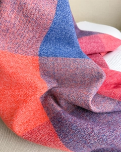 Gros plan d'une écharpe en maille à carreaux orange et bleu avec une texture cachemire