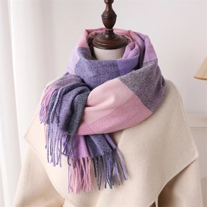 Détail d'une écharpe à carreaux multicolore violet et gris avec des franges longues