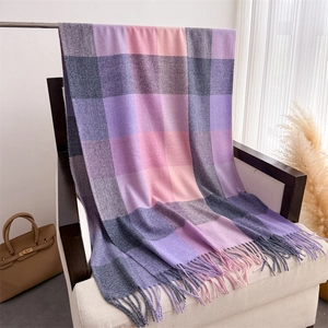 Gros plan d'une écharpe à carreaux multicolores avec de longues franges en imitation cachemire
