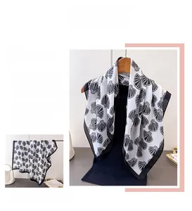 Detail showing the white silk scarf with black shell print and elegant border design
