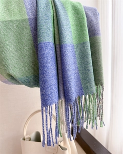 Détail de la texture du tissu à carreaux vert et bleu avec de longues franges