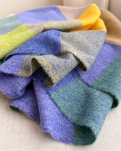 Vue détaillée de la texture douce et du motif à carreaux coloré de l'écharpe