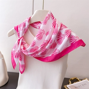 Close-up of pink silk scarf with shell print draped on a mannequin for elegant styling