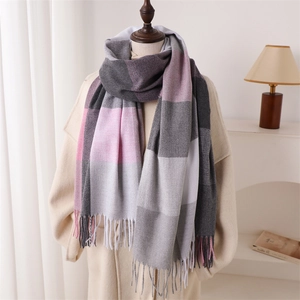 Écharpe à carreaux et franges rose et gris portée sur un manteau d'hiver beige