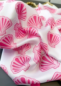 Close-up of silk scarf showing glossy satin fabric and pink seashell pattern details