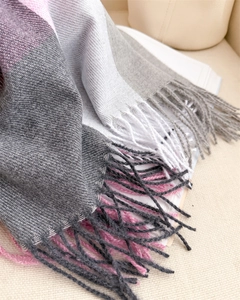 Détail de l'écharpe à carreaux doux avec blocs de couleur violet et gris et longues franges