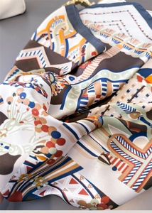 Vista dettagliata della texture liscia della sciarpa in seta con stampe a catena retrò