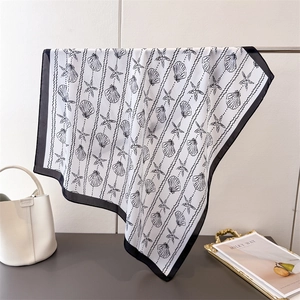 Faux silk scarf featuring shell and starfish prints with black borders on white background