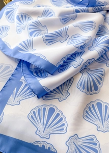 Detailed view of the silk-like fabric featuring blue seashell prints and blue borders