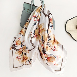 Elegant 90cm square satin silk scarf with yellow magnolia pattern draped on a handbag